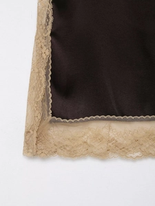 Close-up of dark brown satin fabric with delicate beige lace trim detail on clothing