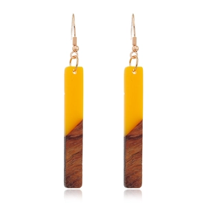 Détails de boucles d'oreilles en bois et résine jaune avec texture bois brun foncé