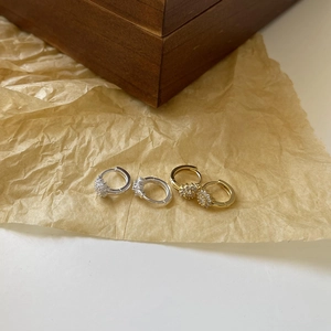 Minimalist S925 silver and gold hoop earrings with cubic zirconia on textured background