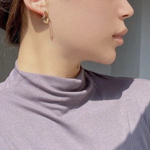 Close-up of golden irregular geometric stud earrings in S925 sterling silver on a model