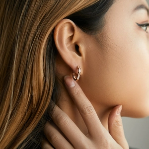 Detailed macro view of gold plated hoop earrings featuring baguette-cut clear zircons