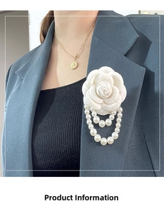 Close-up of a white fabric camellia flower brooch with elegant pearl chain fringe