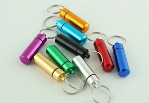 Close-up of waterproof aluminum pill box keychains in various anodized colors