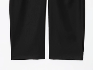 Détail du pantalon ballon noir montrant la texture du tissu et la finition des coutures
