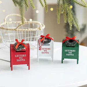 Three decorative metal Christmas mailboxes in red white and green with mini wreaths