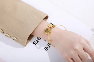 Vue détaillée du bracelet doré ajustable avec pendentifs en forme de cœur gravés