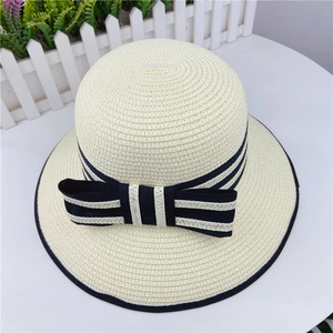 Detailed top view of a woven straw sun hat with blue striped bow and black piping edge