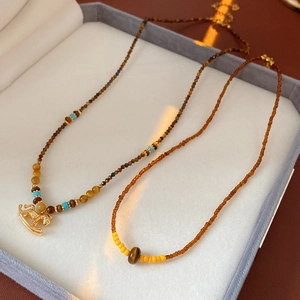 Close-up of vintage beaded necklace with golden rocking horse pendant in jewelry box