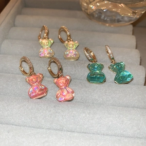 Détail de boucles d'oreilles oursons colorés avec anneaux dorés sertis de zircons