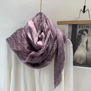 Detailed close-up of purple linen scarf with intricate lace trim on a white outfit