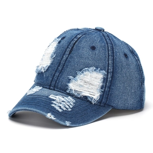 Gros plan sur une casquette de baseball en denim bleu foncé avec des détails déchirés