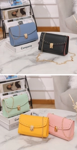 Close-up of litchi-textured leather bags with gold studs and chain strap in multiple colors
