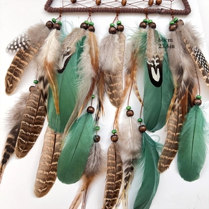 Triangle dream catcher featuring natural brown feathers and vibrant green accents
