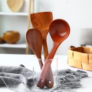 Macro view of natural dark wood kitchen utensils set with spatula and spoons in glass
