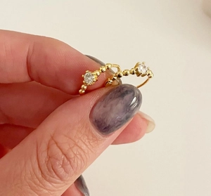 Close-up of gold bead band rings with four-prong set sparkling zircon stones