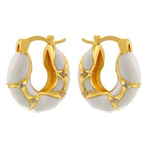 Detailed macro view of gold-plated hollow enamel hoops with clear cubic zirconia stones