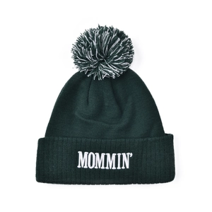 Detailed view of dark green knit beanie with MOMMIN embroidery and pom-pom