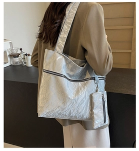 Detail of silver metallic tote bag with pleated texture and detachable mini zipper pouch