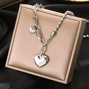 Silver heart pendant necklace with mixed ball and oval link chain on jewelry box