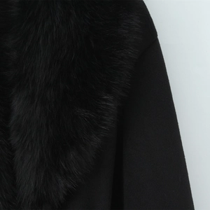 Detailed close-up of the plush black faux fur collar on a long wool blend coat