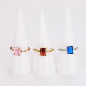 Three elegant stainless steel rings with square colorful zircons on white ring holders