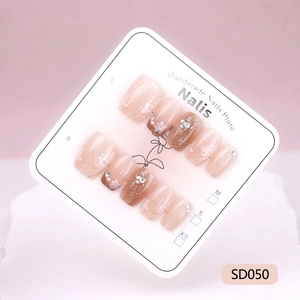 Handmade pink gradient press-on nails with floral art, pearls and glitter accents