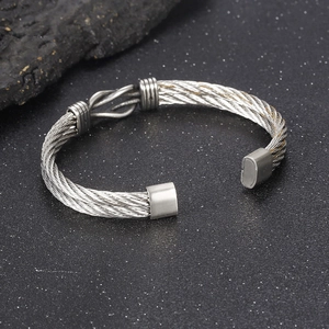 Macro detail of silver twisted cable cuff bracelet with central knot and industrial finish