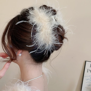 Detail view of a white ostrich feather hair claw clip with rhinestones for women