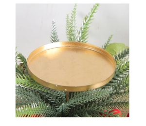 Detail of a gold metallic candle holder base with red berries and pine needles