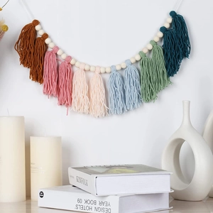 Boho wood bead garland with colorful cotton tassels on a wall for home decoration