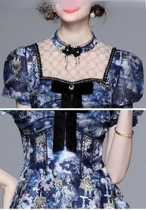 Detailed view of blue dress with lace collar, floral embroidery, and velvet bow