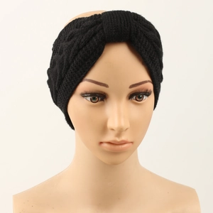 Detail of black cable knit headband with twist knot design for winter ear warmth