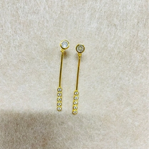 Boucles d'oreilles pendantes plaquées or avec cristaux ronds sur fond en feutre beige