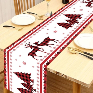 Christmas table runner with red plaid reindeer and tree patterns on a wooden table