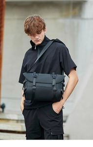 Outdoor shot showing details of black functional messenger bag with buckle adjustment
