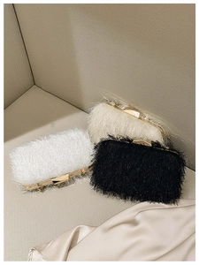 Detailed close-up of fluffy evening clutch bags in white, beige, and black with gold frames