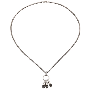 Macro-detail van een sterling zilveren ketting met drie gotische schedelhangers eraan