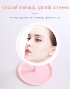 Close-up of pink LED makeup mirror with ring light and storage base on desk