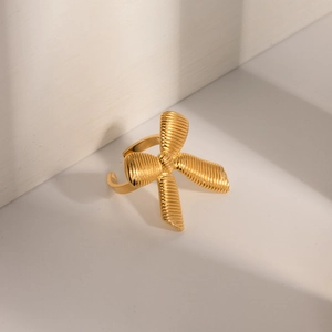 Macro shot of gold bow ring featuring detailed vertical stripes and 3D metallic texture