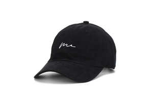 Detail of black cotton baseball cap showing white 'me' script embroidery and 6-panel crown