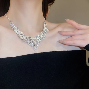 Macro shot of shimmering V-shaped rhinestone necklace on model for evening party looks
