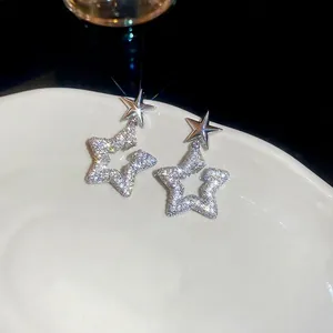 Elegant silver star drop earrings with sparkling cubic zirconia on a white tray