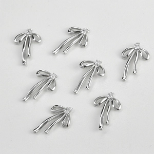 Macro detail of 14k gold-plated bow pendants with sparkling cubic zirconia for DIY jewelry