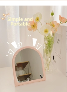 Minimalist Morandi pink arched vanity mirror with foldable stand on a vanity table