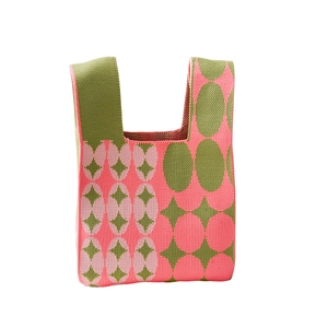 Pink and green knit tote bag with geometric star patterns and minimalist handle