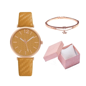 Close-up of women's quartz watch with woven strap and matching star charm bracelet