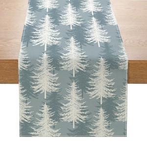 Christmas table runner with white pine tree prints on a grey-blue linen fabric background