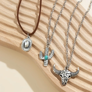 Detail of vintage western necklace set with cactus, cowboy hat and bull skull pendants
