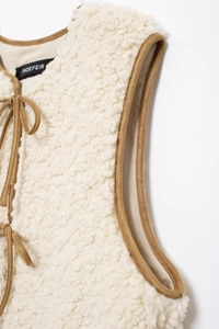 Detail of faux shearling vest with contrast suede trim and tie-front closure design