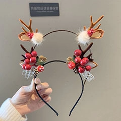 Detailed view of Christmas elk antler hair clips with red berries and lace decor